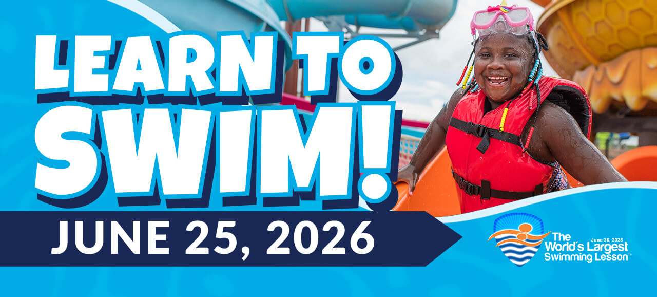 Blog feature image with the text "The World's Largest Swimming Lesson" on "June 25, 2026" at Soaky Mountain Waterpark. Has a decorative background with with two girls on the left putting on swimming goggles. On the right is a girl smiling in a life jacket.